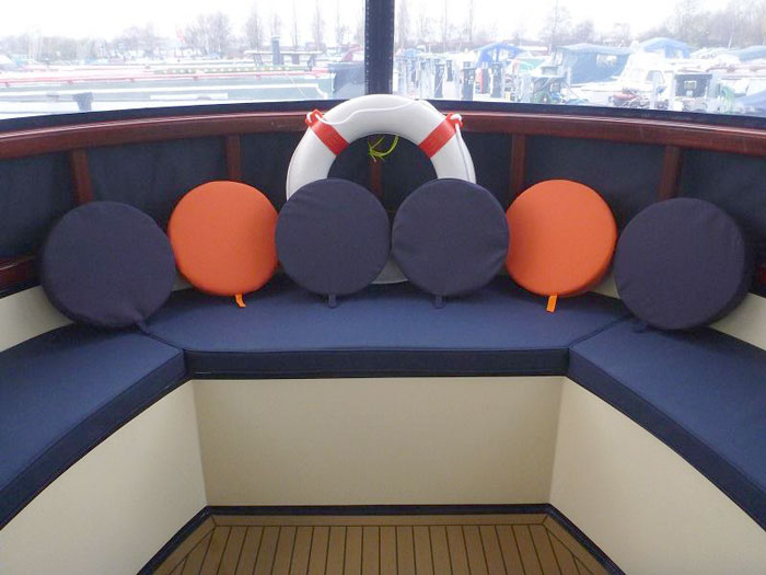 A re-upholstered boat seating area with porthole covers/cushions